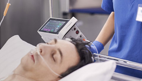 a man lying on a bed with a medical device